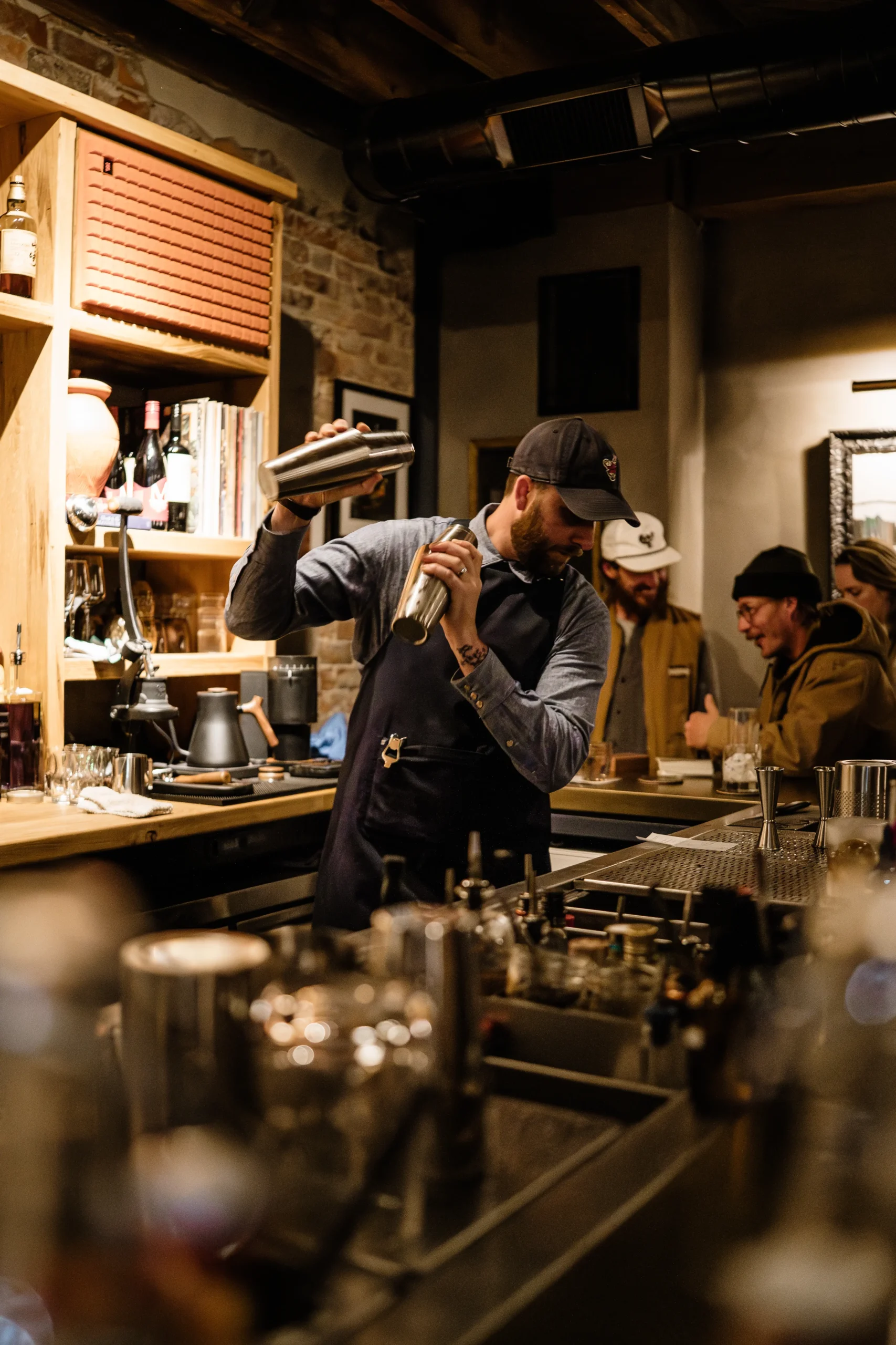 Bevel bar in downtown waynesville north carolina located in the back of axe and awl leatherworks featuring bar owner, spencer, shaking a cocktail behind the bar